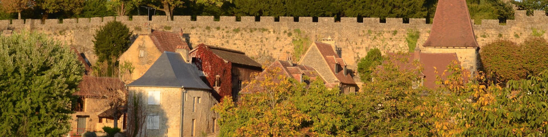 Castle Montfort high above the Dordogneriver in France, in the eveningsun glowing