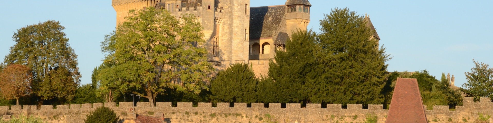 Castle Montfort high above the Dordogneriver in France, in the eveningsun glowing