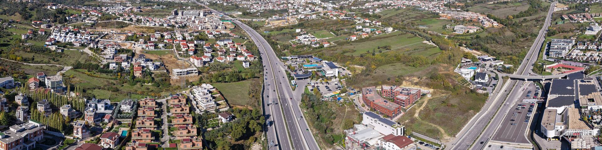 Panoramic aerial view of Tirana–Elbasan Highway through Sauk and Farkë showing Tirana’s urban expansion toward the east.