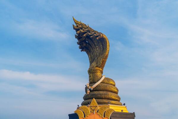 Landmarks Statue of the Naga serpent of seven heads belief in buddhism name Phraya Srisatta Nakarat at the mekong river in Nakhon Phanom, Thailand.
