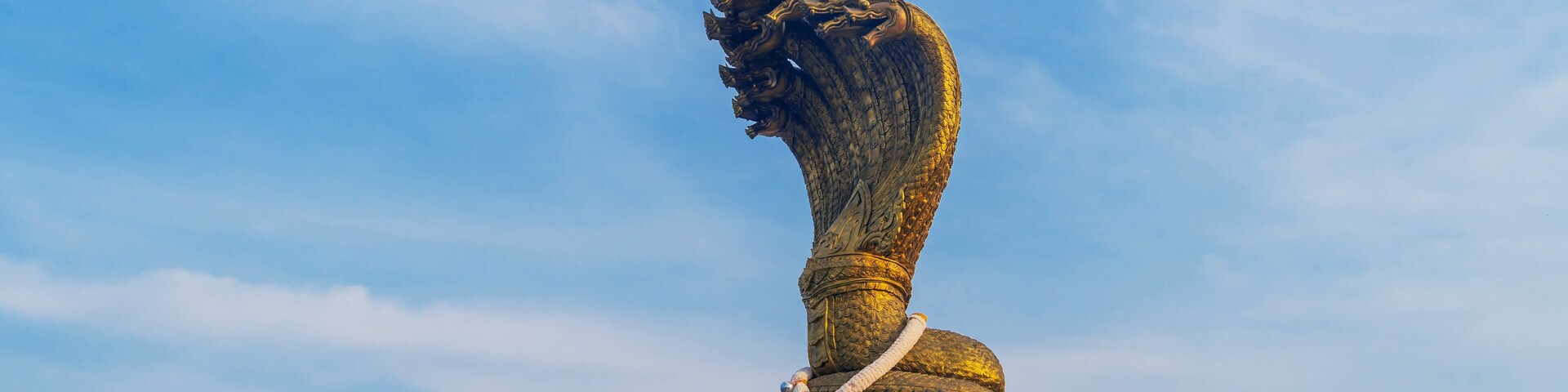 Landmarks Statue of the Naga serpent of seven heads belief in buddhism name Phraya Srisatta Nakarat at the mekong river in Nakhon Phanom, Thailand.
