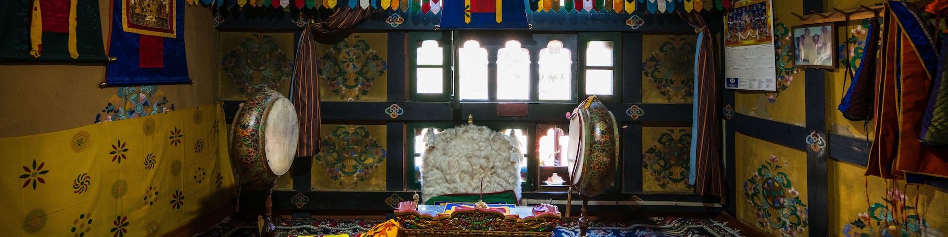 Ha, Bhutan - 26 September 2025: View of an ornately decorated altar interior where vibrant colors dance across walls adorned with traditional patterns, illuminating the antique wooden floor.