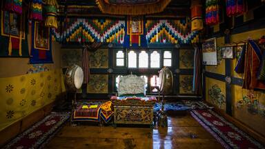 Ha, Bhutan - 26 September 2025: View of an ornately decorated altar interior where vibrant colors dance across walls adorned with traditional patterns, illuminating the antique wooden floor.