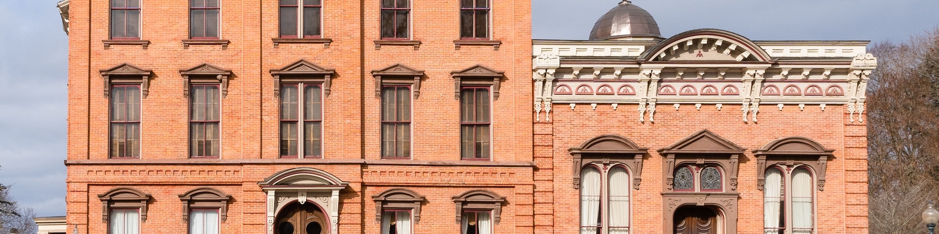 A red brick building with ornate architectural details, including a dome and decorative windows.