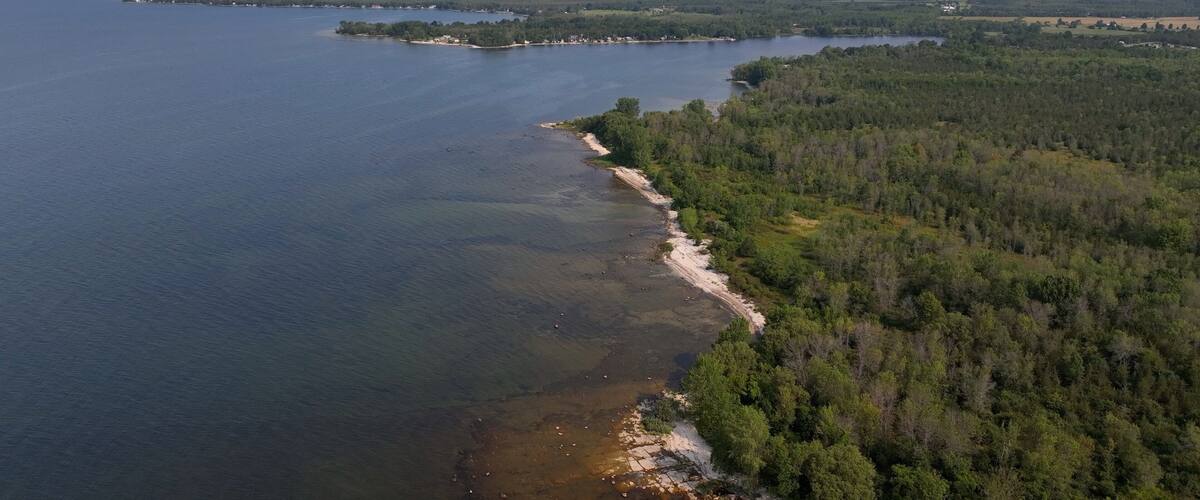 Beach front shoreline on Lake Ontario coast peaceful water blue sky morning light conservation nature preserve at Black Pond Beach in New York