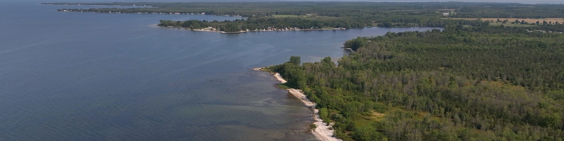 Beach front shoreline on Lake Ontario coast peaceful water blue sky morning light conservation nature preserve at Black Pond Beach in New York