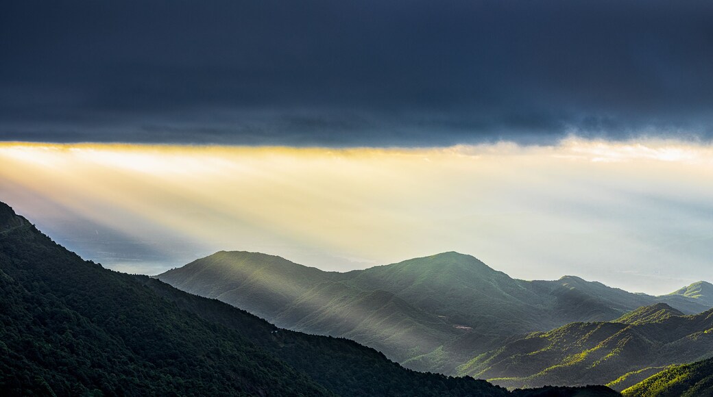 A view of the Tyndall effect and wind turbines at sunrise on Queya Mountain in Heyuan, Guangdong.