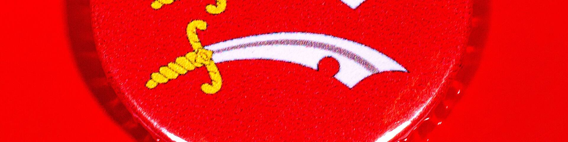 A red and white emblem with yellow and white curved lines.