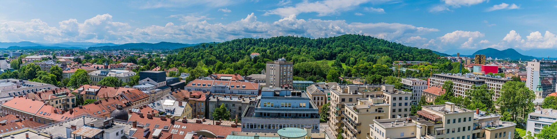 A panorama view over rooftops towards Tivoli Park from central Ljubljana, Slovenia in summertime