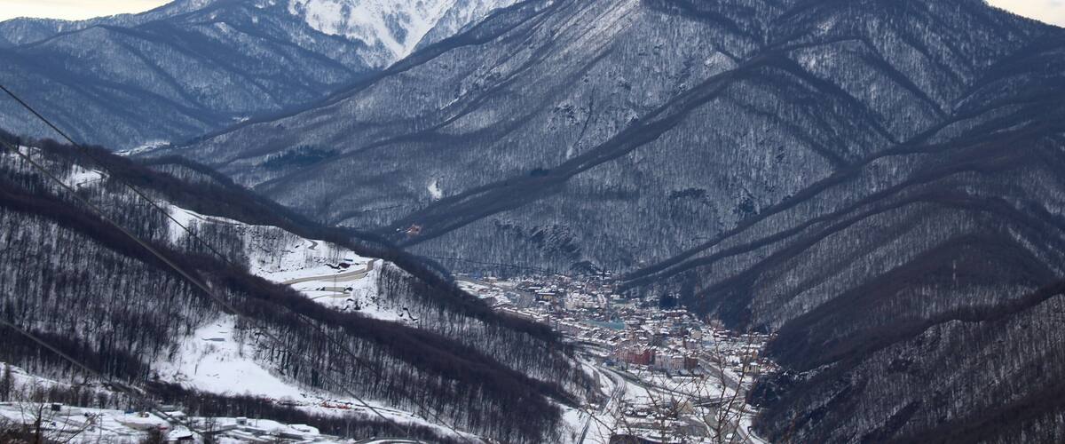 A snow-covered mountain range with a town nestled in a valley.