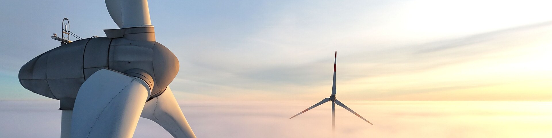 Dos aerogeneradores en un paisaje brumoso.