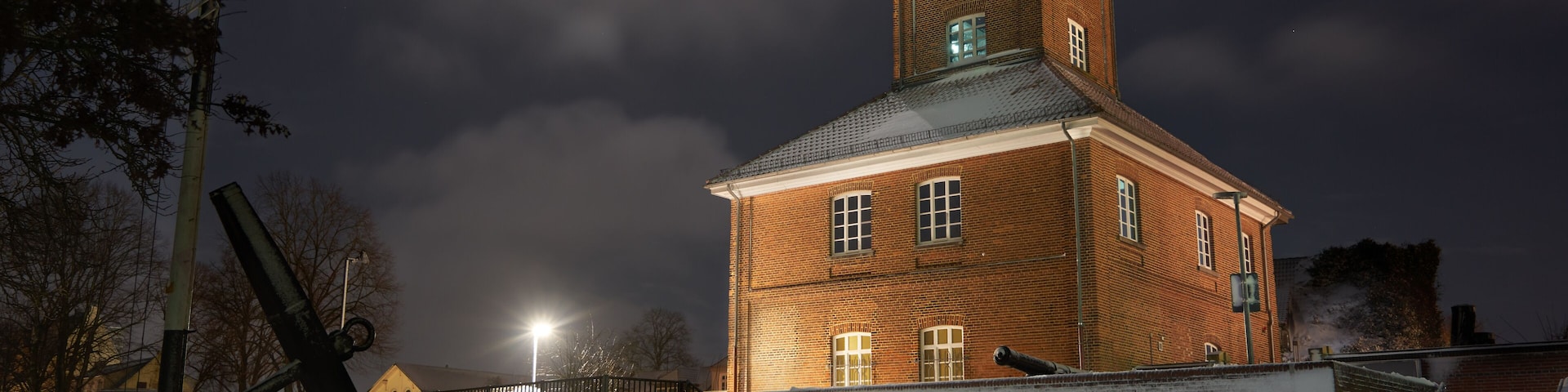 the historical telegraph building in Brake Unterweser (district Wesermarsch, Germany) on a bright snowy fullmoon night with vivid clouds in the sky;