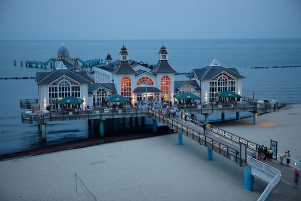 Eine Pier mit einem großzügigen Gebäude, das Bogenfenster und eine Kuppel aufweist, die sich ins Wasser erstreckt.