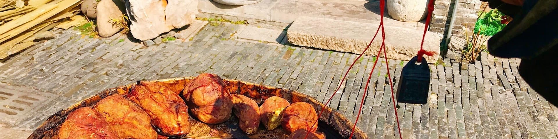 Roasted sweet potatoes on a large outdoor grill.