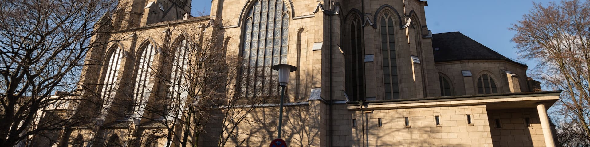 A historic church with a tall bell tower and large arched windows.