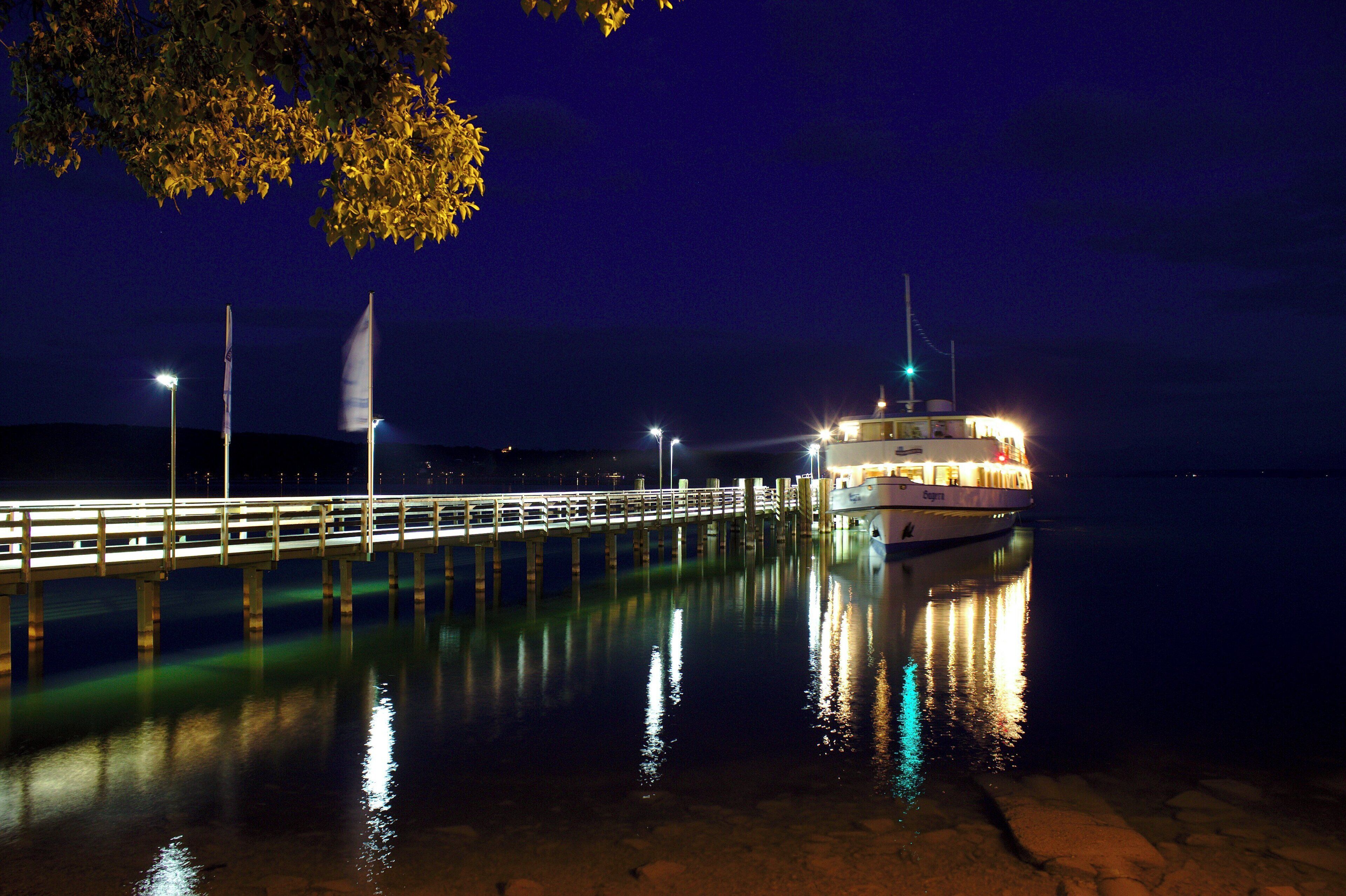 The cruise ship MS Bayern docking to unload passengers on the Starnberger See at night.