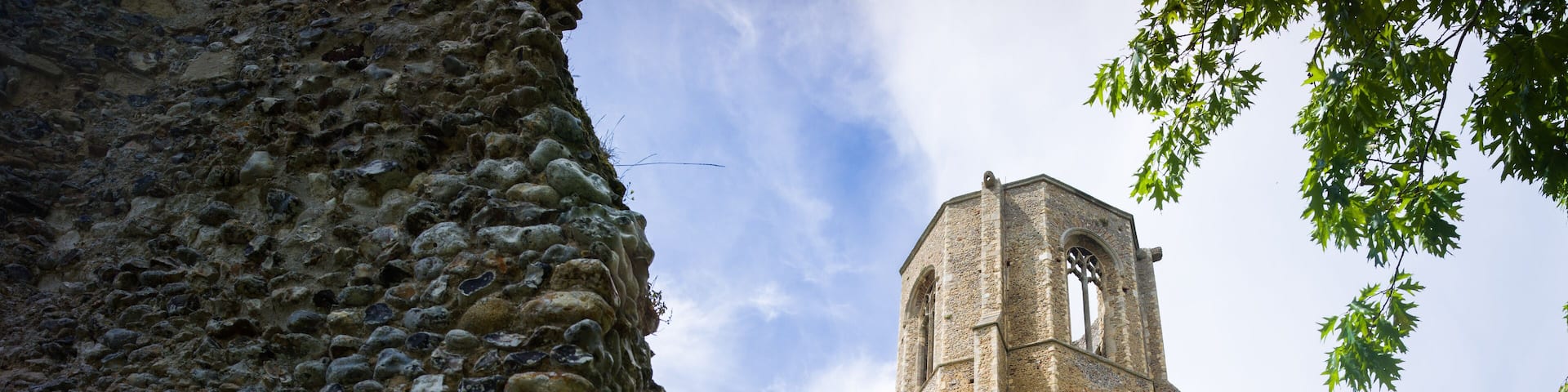 A historic stone building with a tall bell tower and arched windows.
