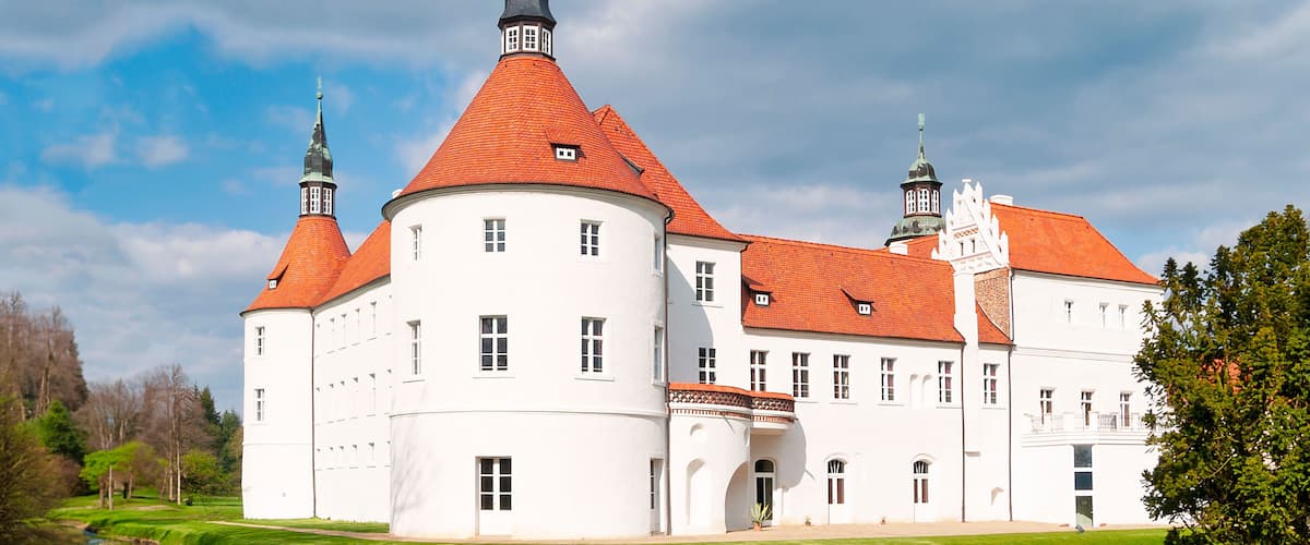 A large white building with red roofs and multiple towers.