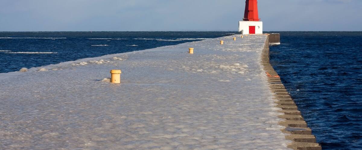 Winter landscape with lighthouse. Scenic view with lake Michigan and Menominee North Pier lighthouse in cold morning sun light. Midwest USA, state Michigan. Grate Lakes and travel America background.