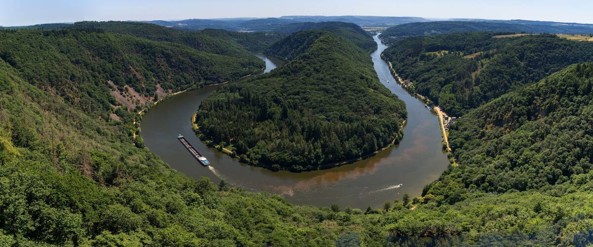 view of the Great Bend in the Saar at Mettlach with a cargo ship passing