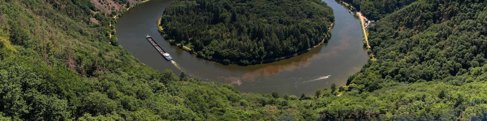 view of the Great Bend in the Saar at Mettlach with a cargo ship passing