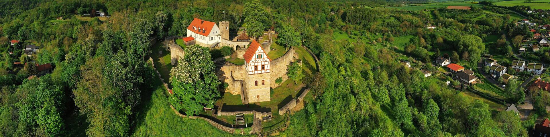 A historic town with a prominent church, surrounded by lush greenery and rolling hills.