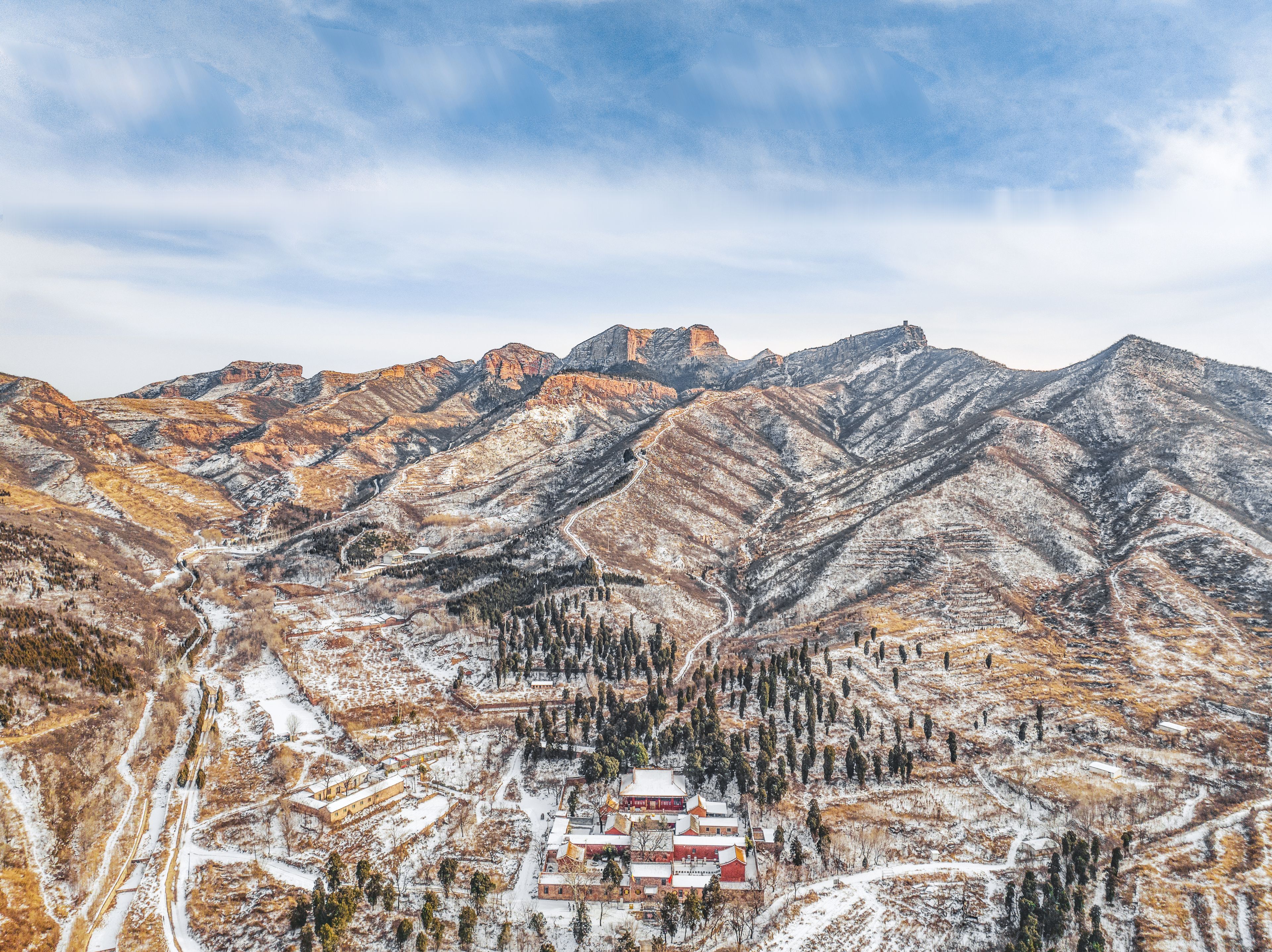 A mountainous landscape with a small settlement at its base.