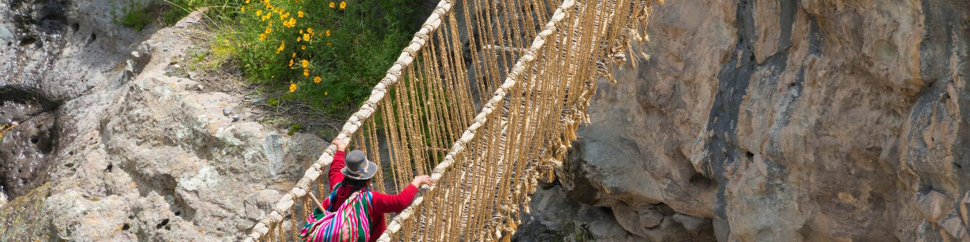 Quechua woman crossing Queshuachaca (Q'eswachaka) rope bridge, one of the last standing Incan handwoven bridges, Quehue, Canas Province, Peru