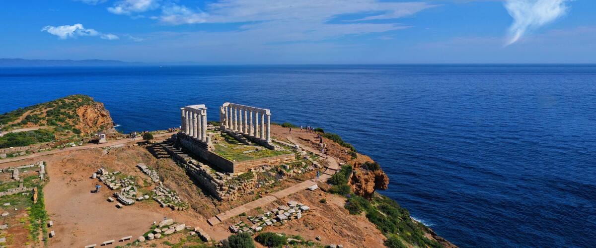 Aerial drone ultra wide photo of iconic Temple of Poseidon in Southern part of Attica, Cape Sounion, Greece