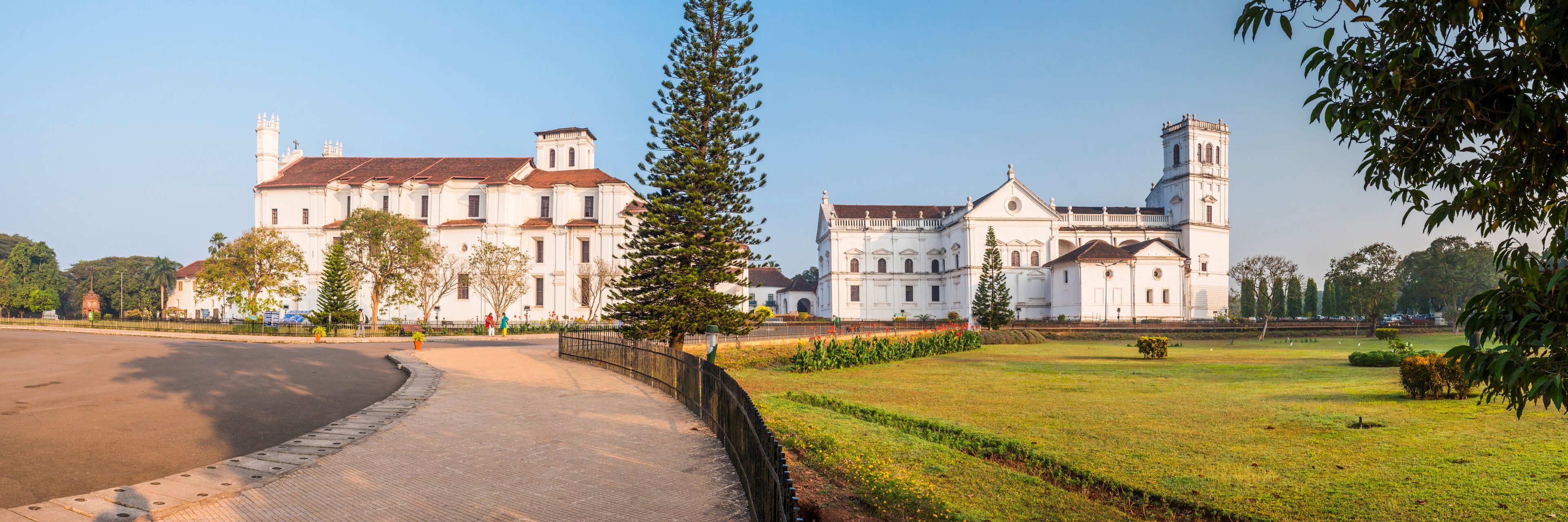 A large white colonial-style building with a prominent tower, surrounded by a well-maintained lawn and a curved pathway.