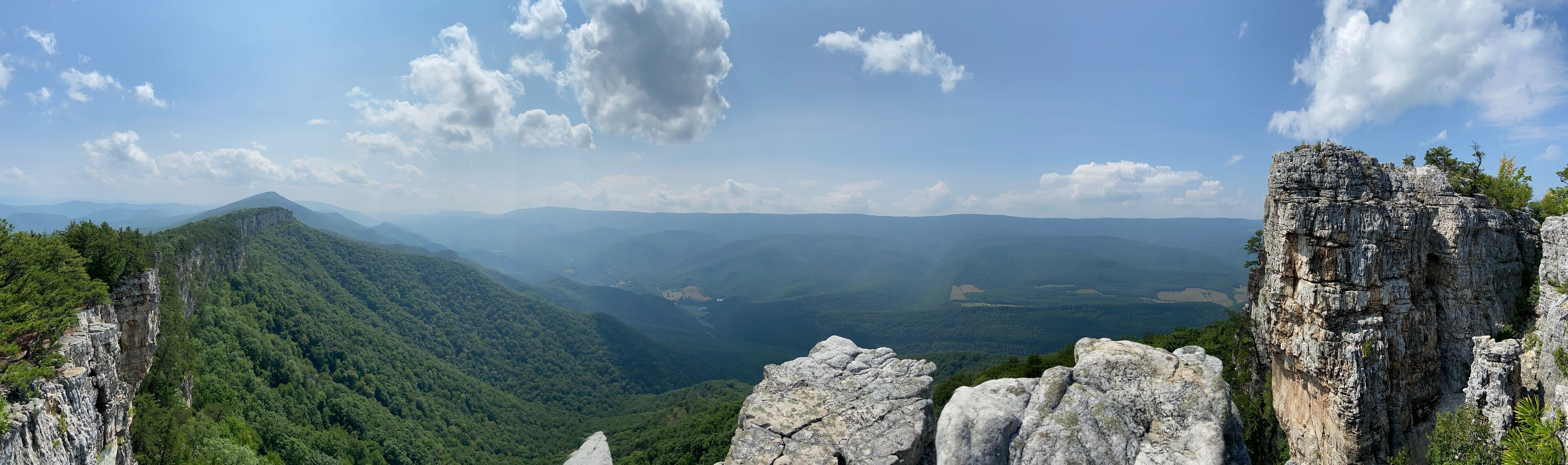 A mountainous landscape with rocky outcrops and dense forest.