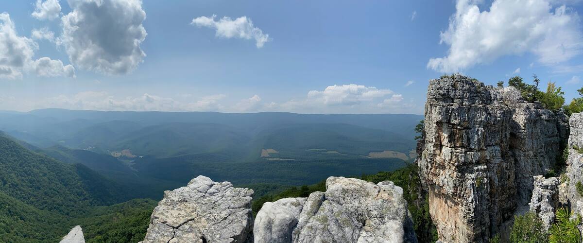 A mountainous landscape with rocky outcrops and dense forest.