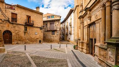 Square with old buildings and facade of a Catholic church in the medieval village of Cretas, Teruel, Matarrana
