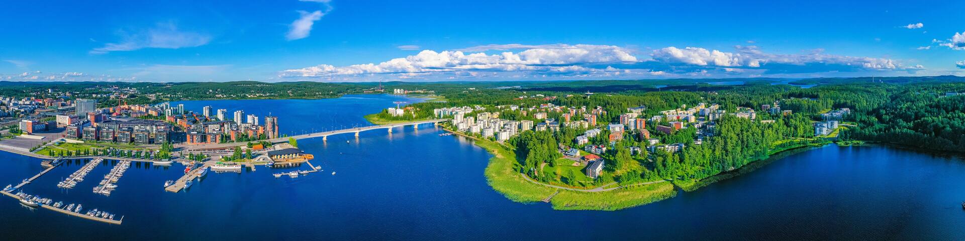 A coastal city with a marina, dense urban area, and a forested peninsula.