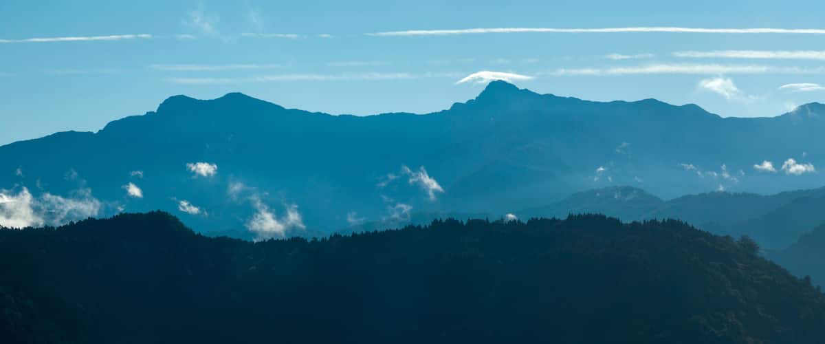A mountain range with a clear sky and some clouds.
