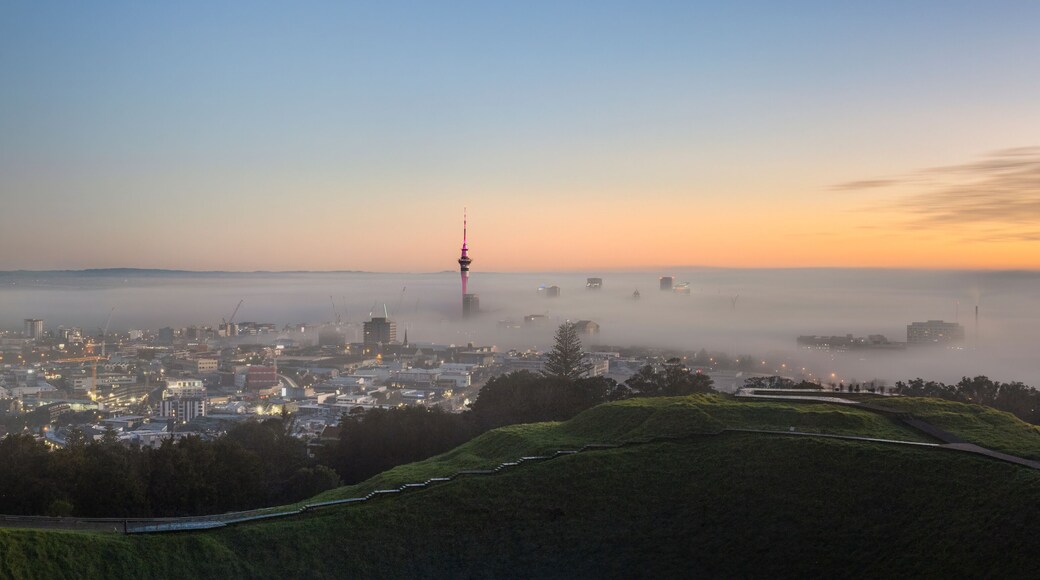Panoramic view of Sky Tower and Auckland city in the fog, from Mount Eden summit.