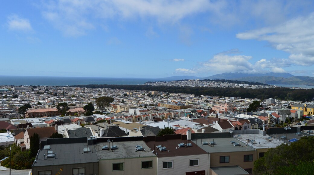 View over several western neighborhoods in San Francisco, including Golden Gate Park, with the Pacific Ocean visible in the background.