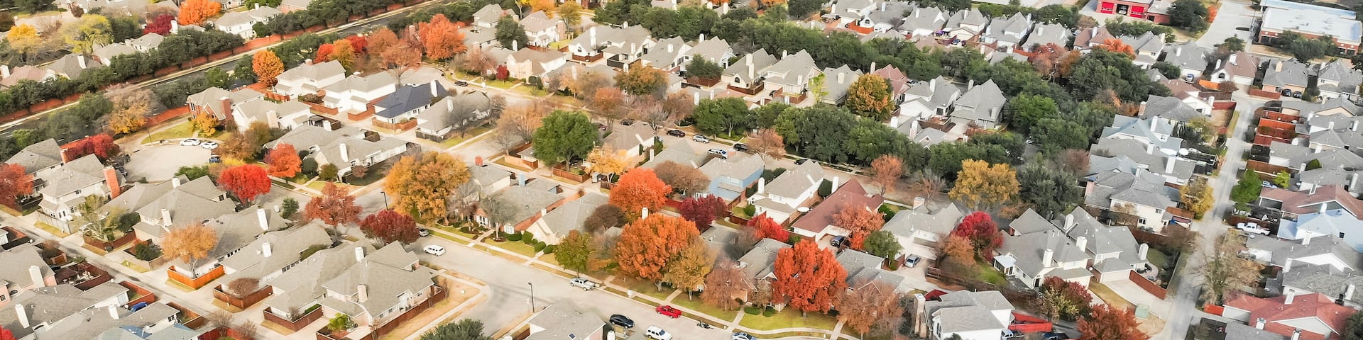 Panorama aerial view of Valley Ranch planned unit development in the Dallas, Texas suburb of Irving, Texas, USA. Colorful fall foliage leaves near row of single-family homes, urban sprawl subdivision