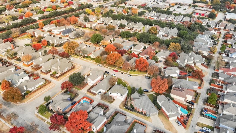 Panorama aerial view of Valley Ranch planned unit development in the Dallas, Texas suburb of Irving, Texas, USA. Colorful fall foliage leaves near row of single-family homes, urban sprawl subdivision