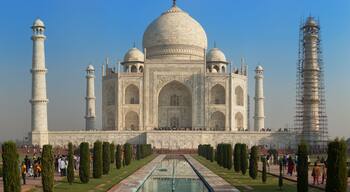 De Taj Mahal met vier minaretten, een centrale koepel en een spiegelbeeld in het water.