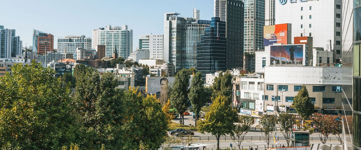 Paisagem urbana com edifícios modernos e arranha-céus, uma combinação de construções comerciais e residenciais, e céu claro.