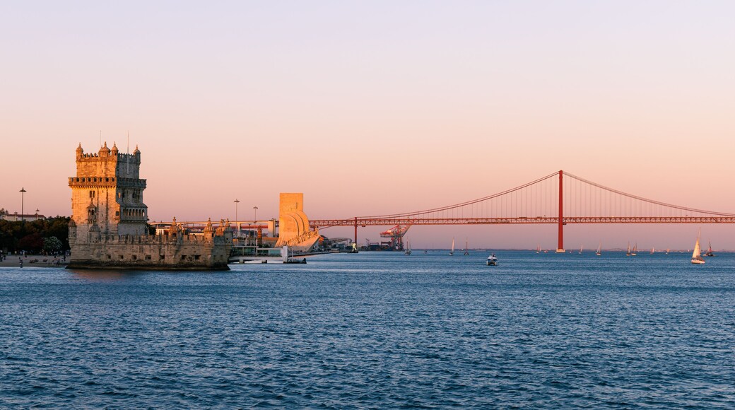 Panorama of Belém in Lisbon, the capital of Portugal. Sunset over Tagus river. Cityscape with Torre de Belém, Belém Tower and red iconic 25 de Abril Bridge, 25th of April Bridge.