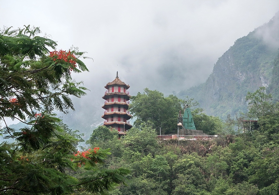 Una pagoda rodeada de exuberante vegetación y montañas.