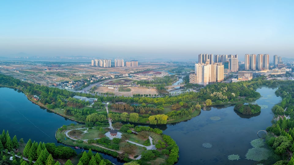Janghang-dong, Ilsan, Goyang-si, Gyeonggi-do, South Korea - May 4, 2024: Aerial and spring view of trees with Moonrise Island on lake at Ilsan Lake Park against apartments