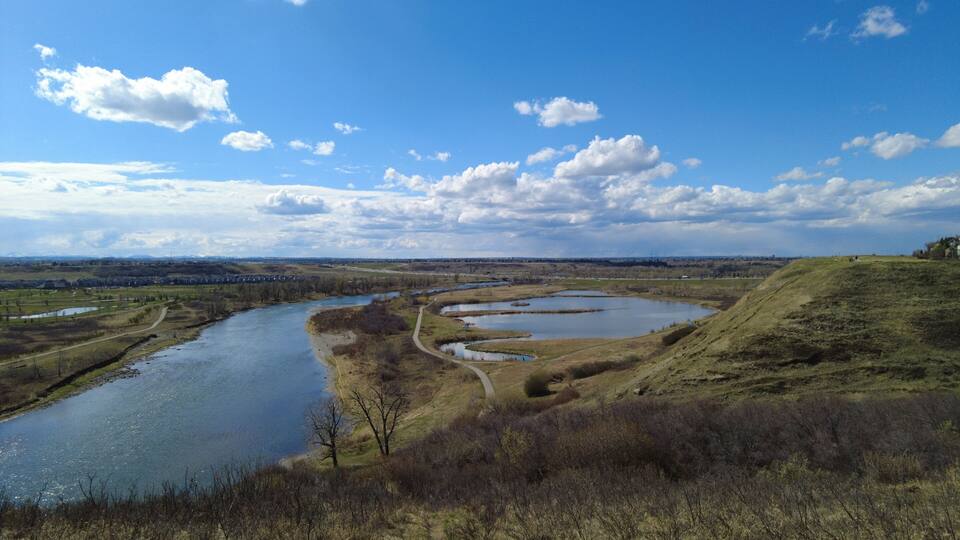 A river winding through a landscape with multiple ponds and a hilly terrain.