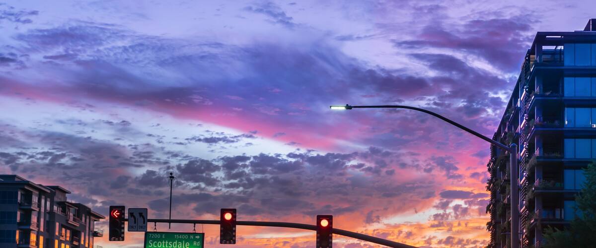 Dramatic sunset in North Scottsdale,Arizona. Cars drive by a busy intersection on Scottsdale rd and Kierland Blvd. Focus on road sign.