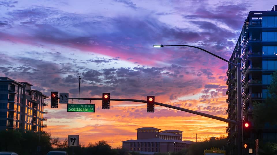 Dramatic sunset in North Scottsdale,Arizona. Cars drive by a busy intersection on Scottsdale rd and Kierland Blvd. Focus on road sign.