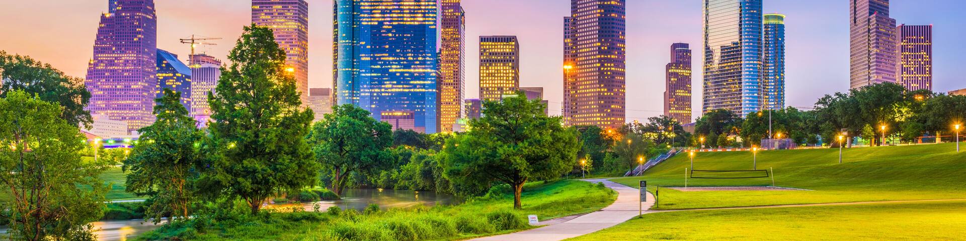 Un horizonte urbano con rascacielos modernos y un parque con un sendero.