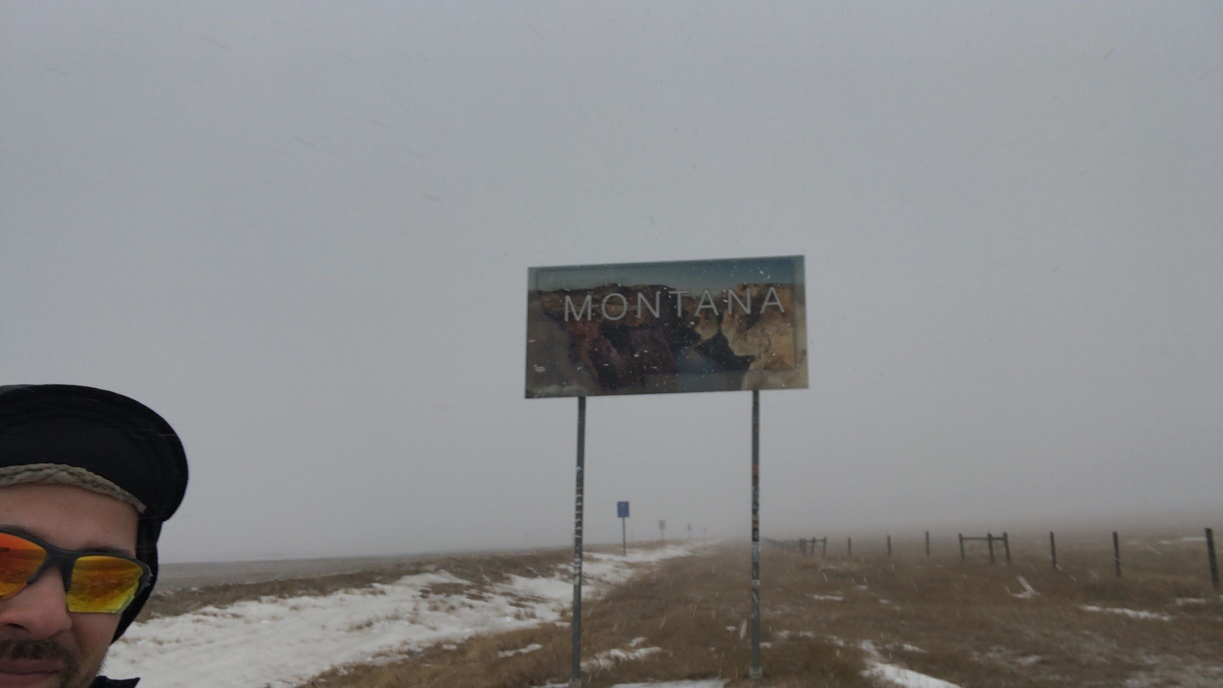 A sign reading "MONTANA" with a snowy landscape in the background.