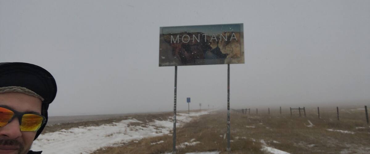 A sign reading "MONTANA" with a snowy landscape in the background.